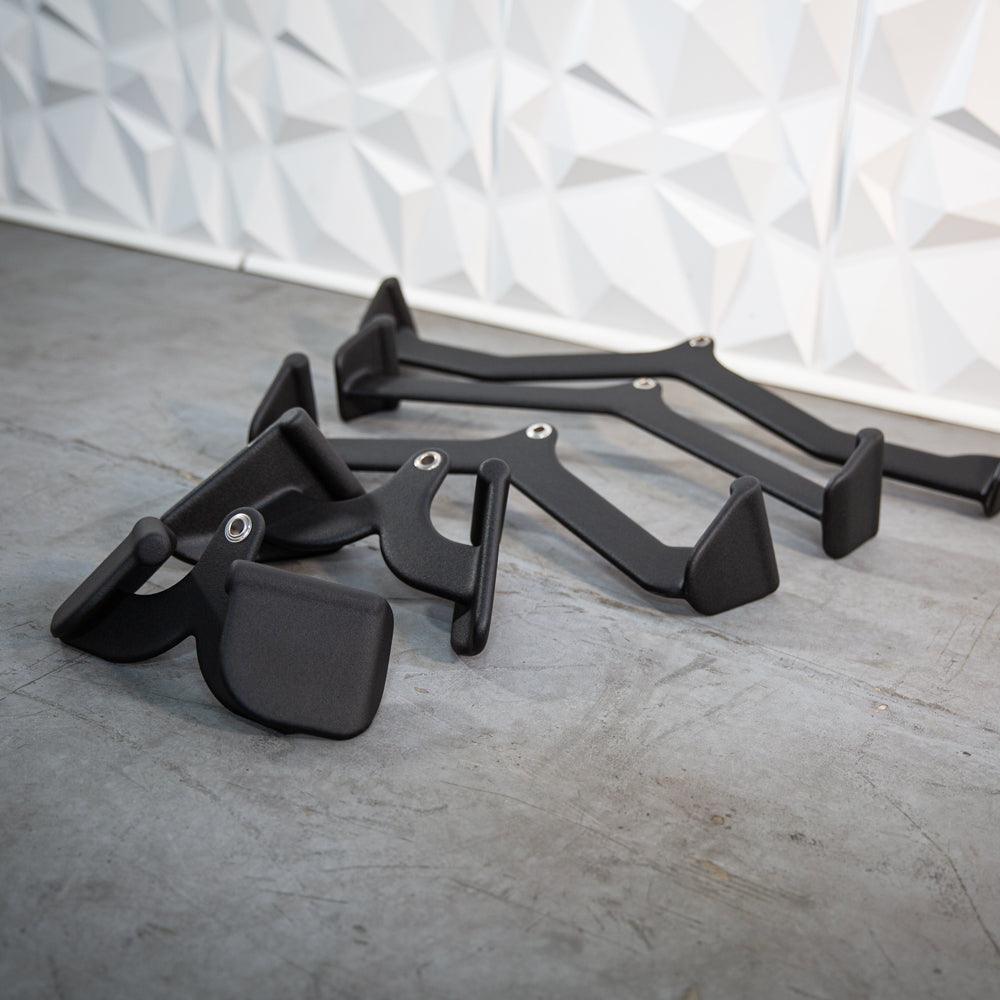 Set of black metal cabinet handles and brackets on a gray floor.