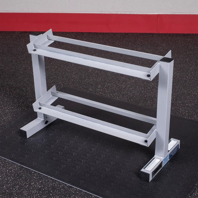 A gray weight rack with two horizontal bars for storing weights, positioned on a black floor mat in a gym setting.