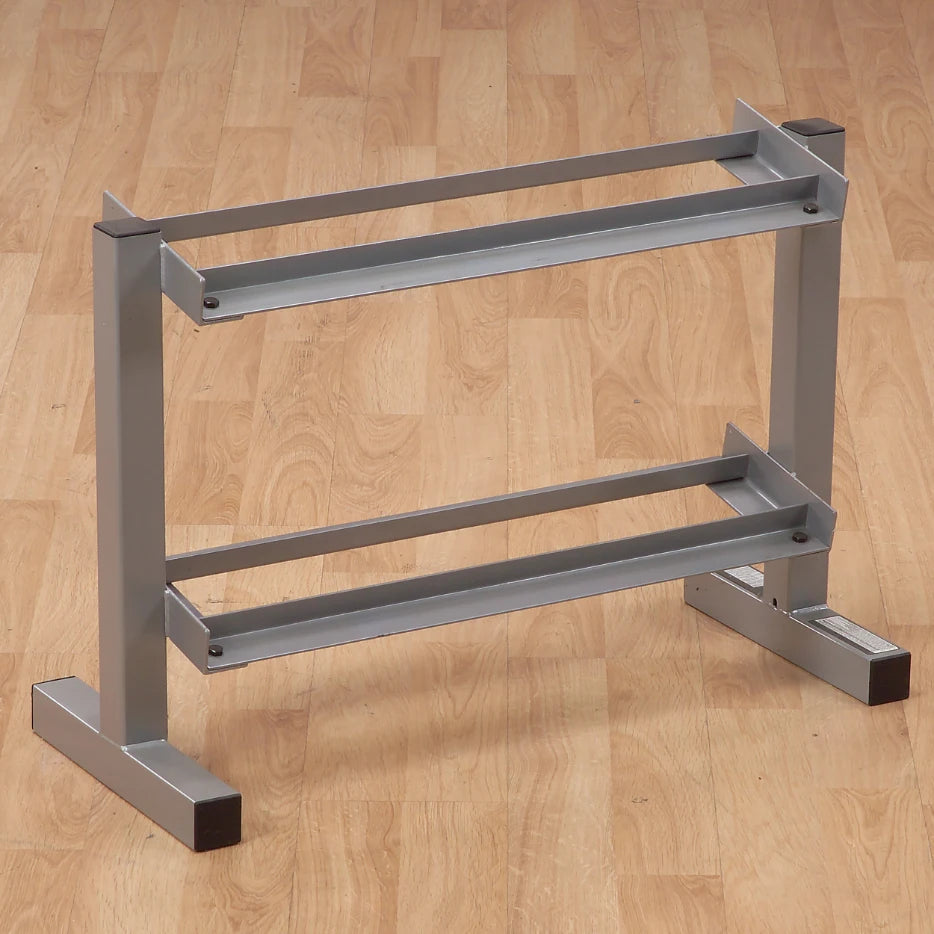 A metal shoe rack with two horizontal shelves, designed to hold shoes, positioned on a wooden floor.