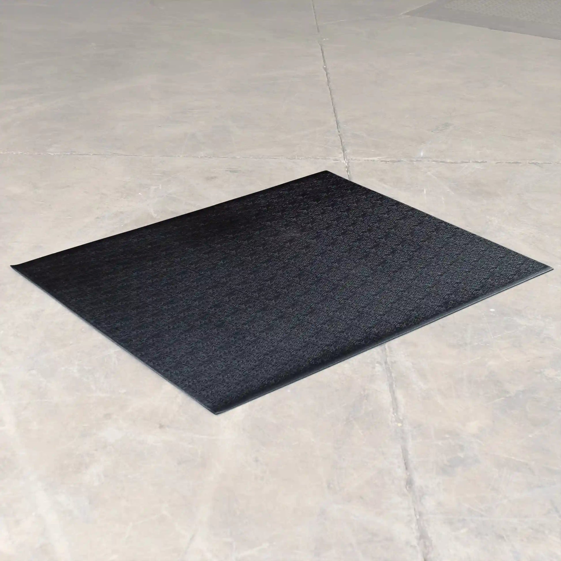 Black anti-fatigue mat on concrete floor.