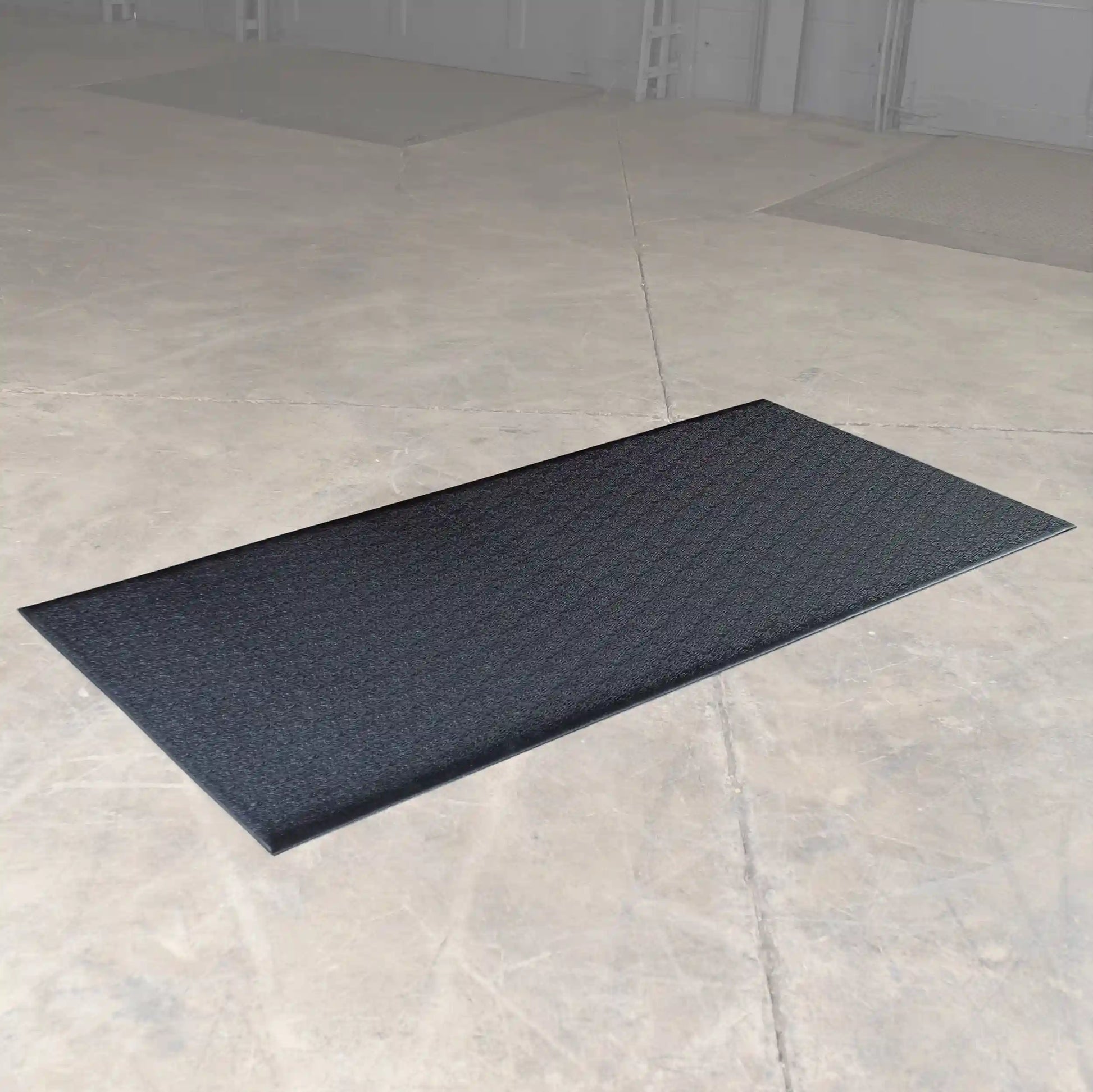 Black anti-fatigue mat on concrete floor.