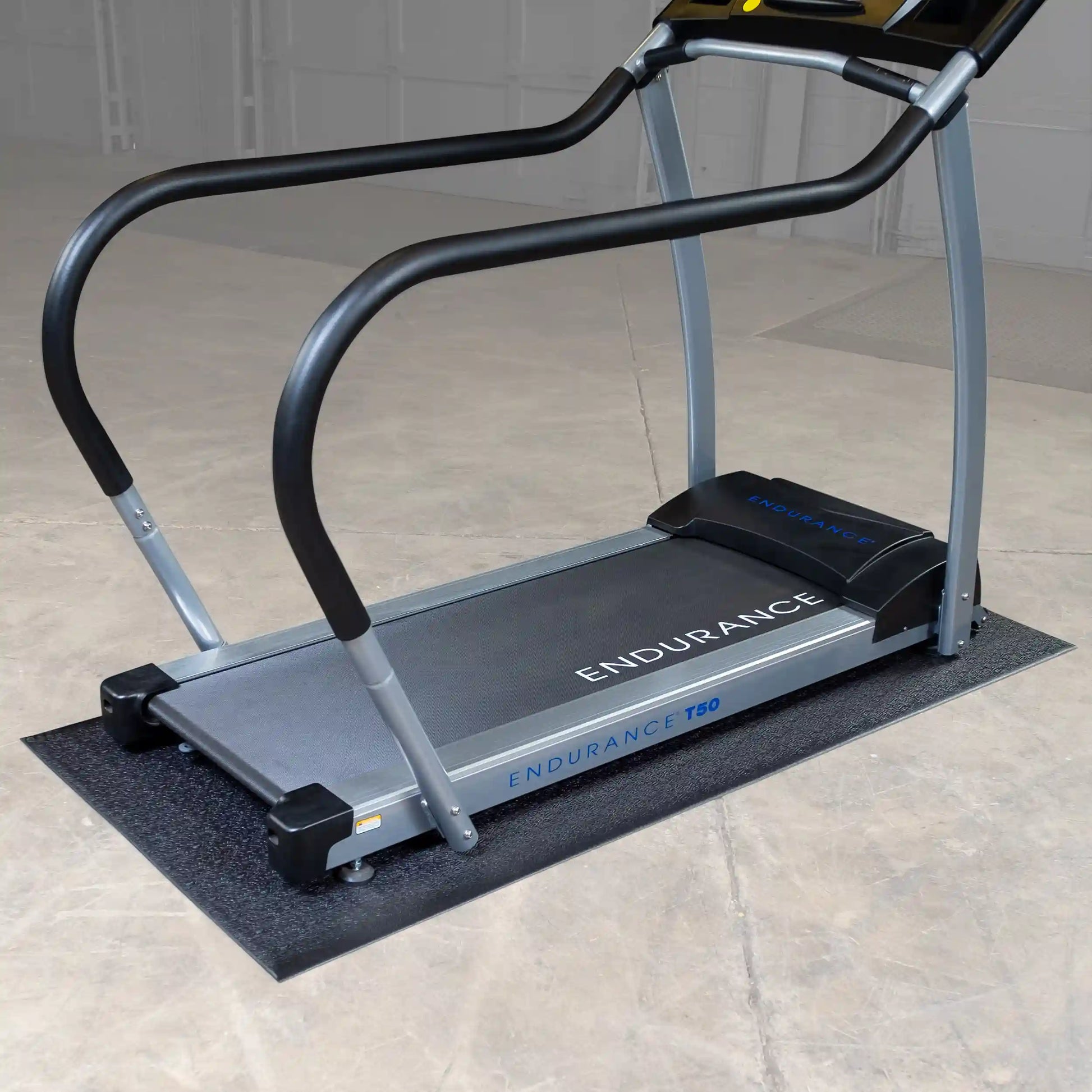 Endurance T50 treadmill with black handrails on a concrete floor.