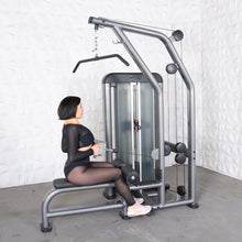 Woman exercising on a sleek gray gym machine, focusing on strength training for fitness.