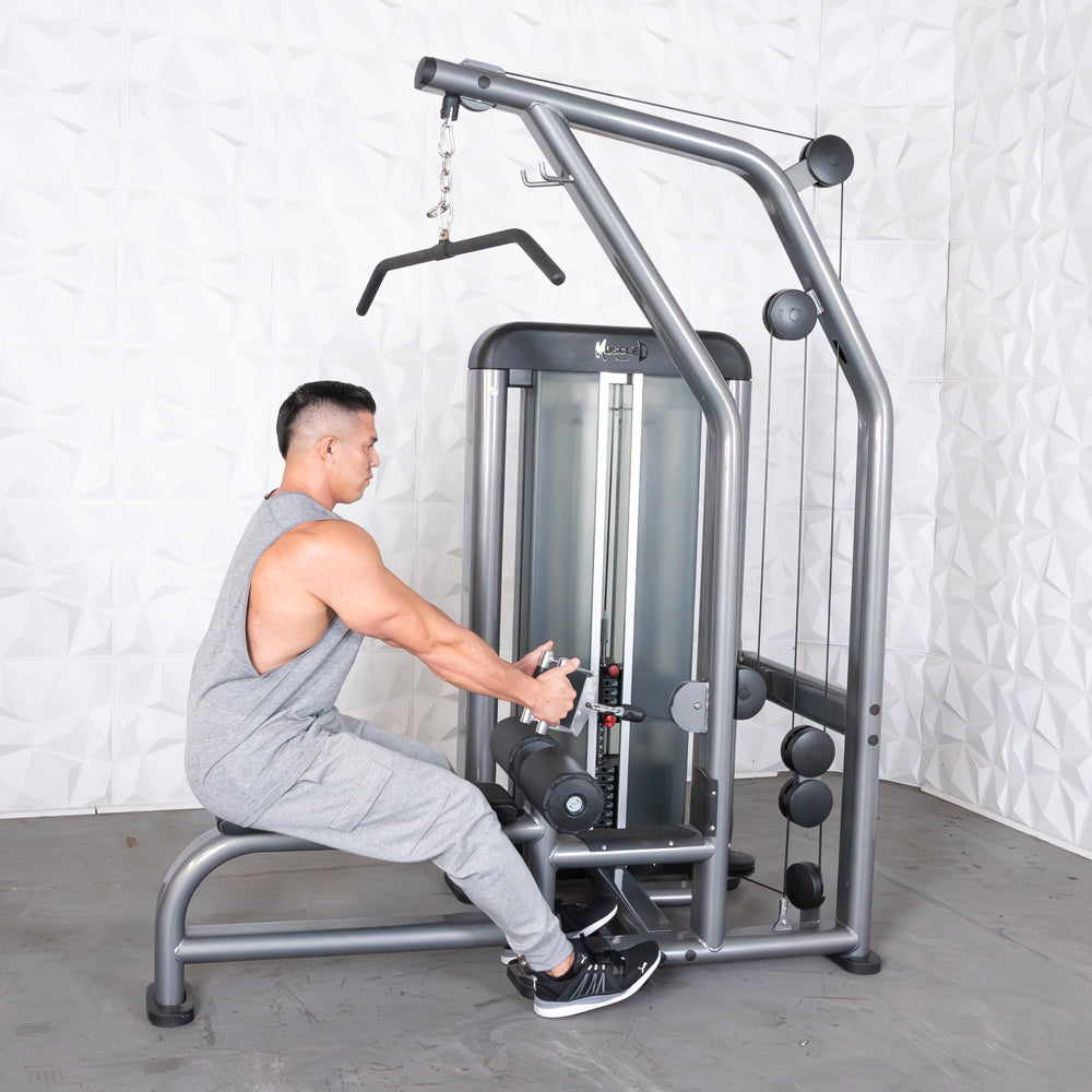 Man exercising on a versatile gym machine with gray finish, focusing on strength training.