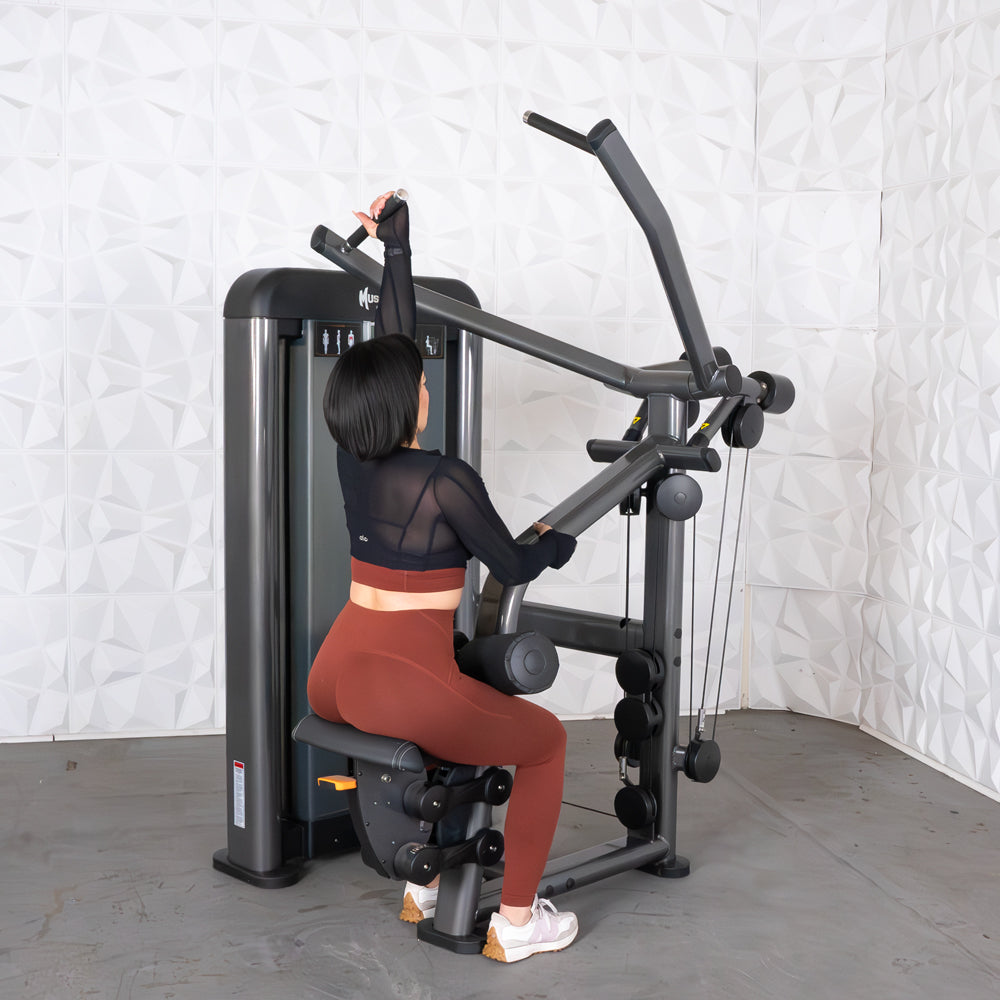 Woman using a Muse Fitness chest press machine in a gym.