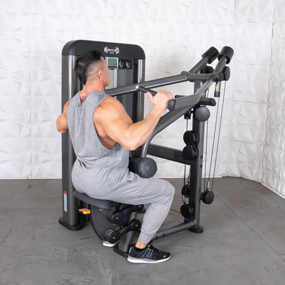 Man using MuscleD lat pulldown machine in gray tracksuit.