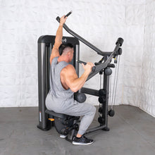 Man using Muscle D lat pulldown machine in gray workout attire.