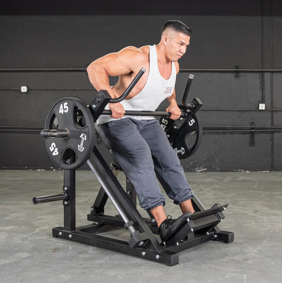Man using a plate-loaded row machine in gym.