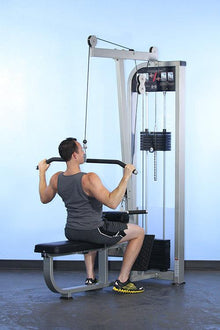 Man using lat pulldown machine with weights in gym, wearing gray tank top.