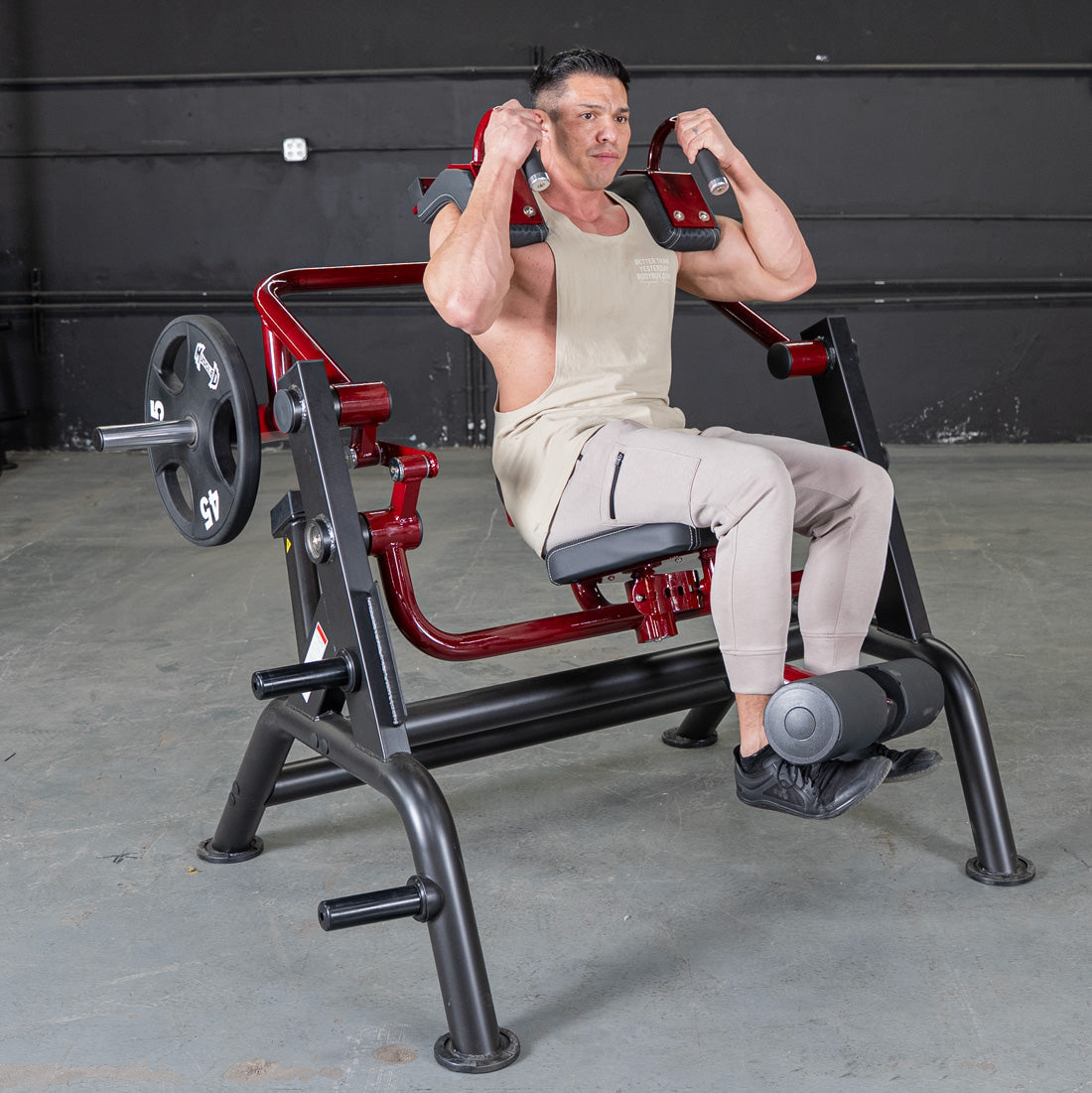 Man using red and black leg press machine for strength training.
