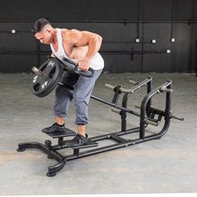 Man using T-Bar Row Machine for back workout, featuring adjustable foot platform.