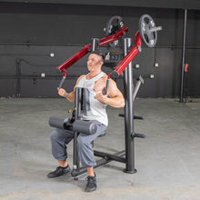 Man using red chest press machine in a gym.