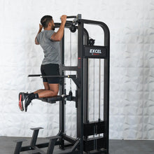 Man using Excel pull-up machine in a gym setting.