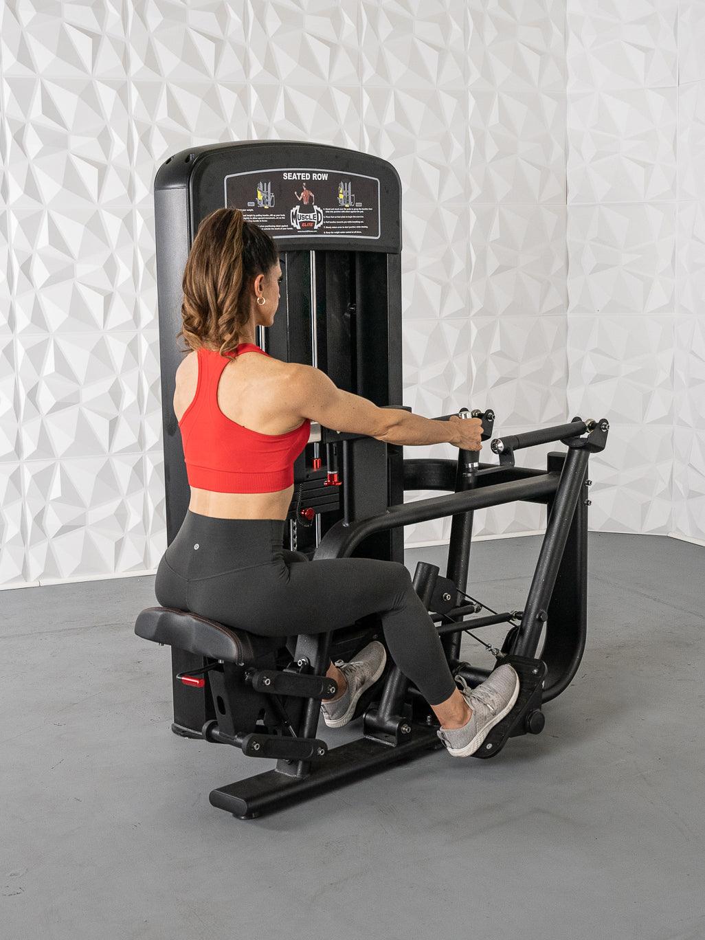 Woman using a seated row machine in a red top for strength training.