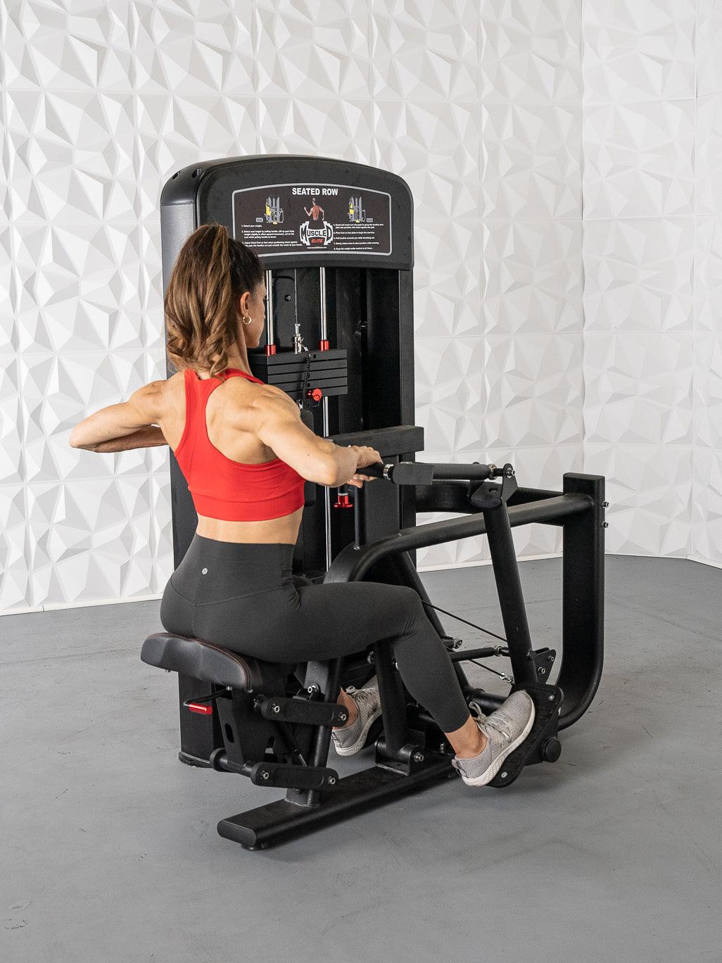 Woman using seated row machine in gym, wearing red sports bra and black leggings.