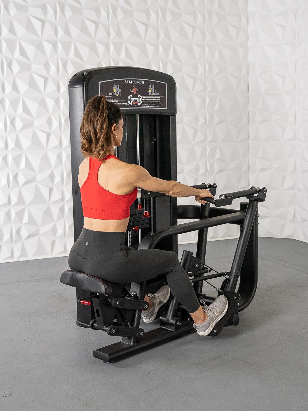 Woman using seated row machine in red top for strength training.