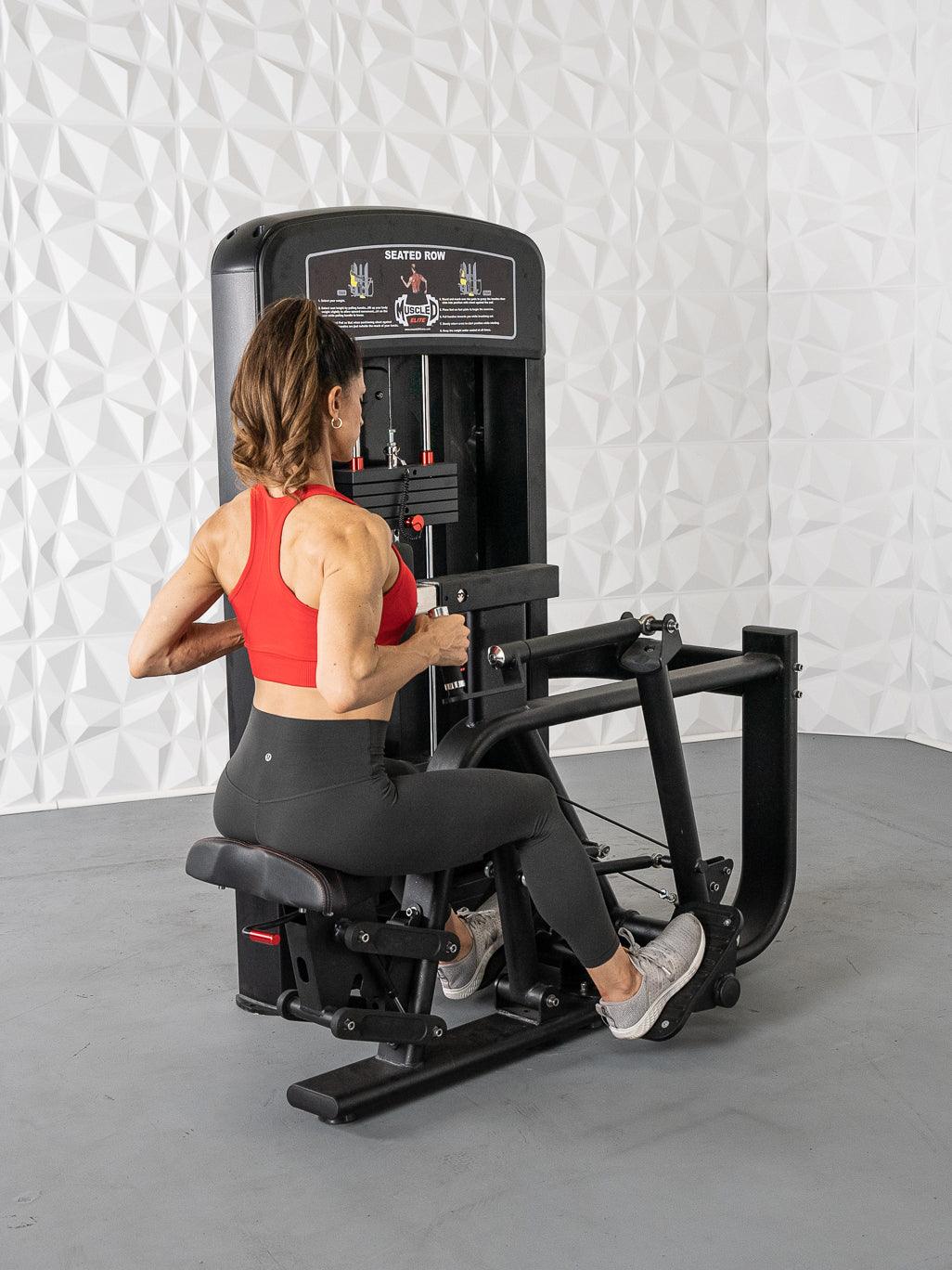 Woman using Muscle D Seated Row machine in red top and black leggings.