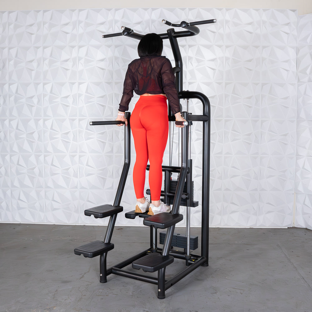 Woman using a vertical climber machine in red leggings for fitness workout.