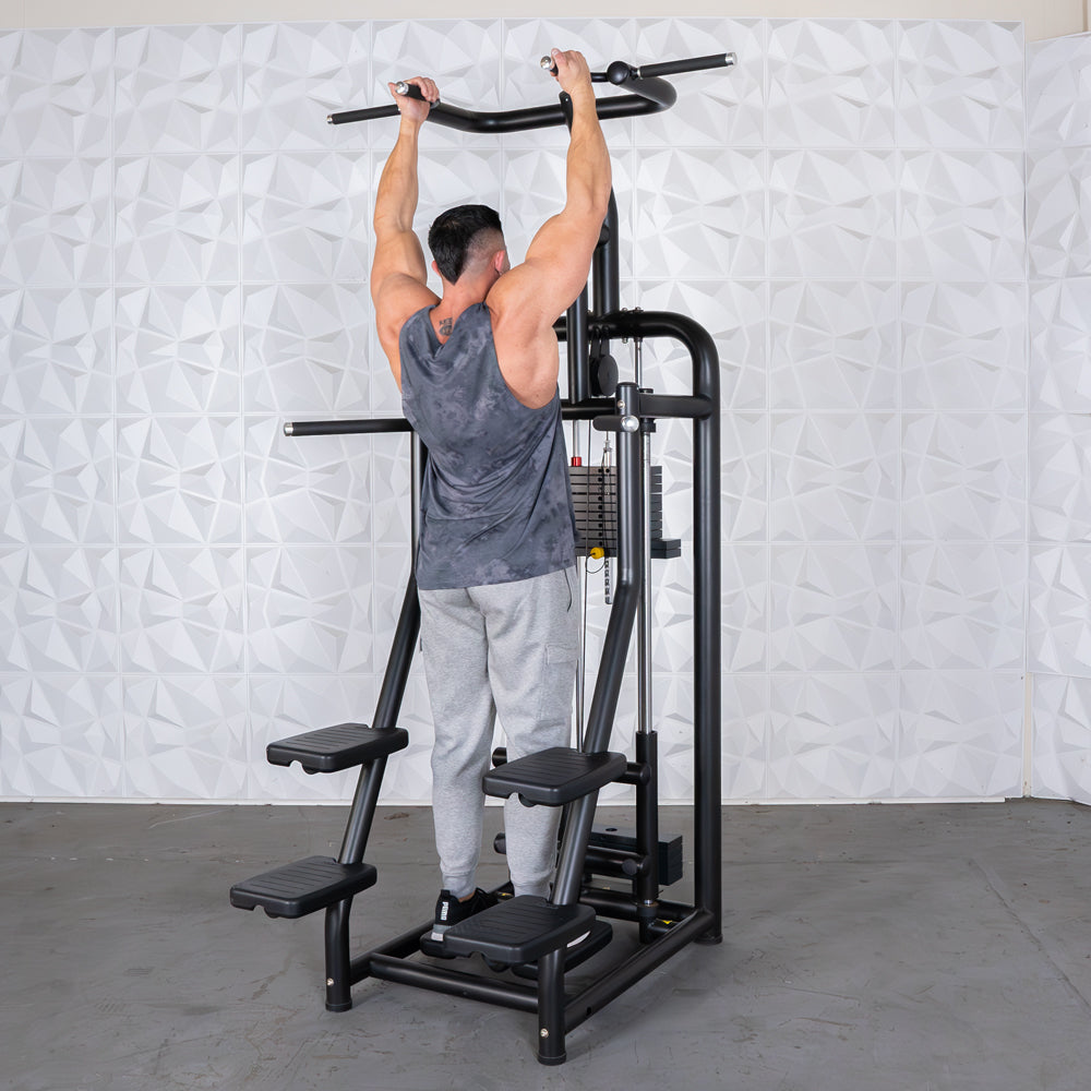 Man using black pull-up assist machine in gym.