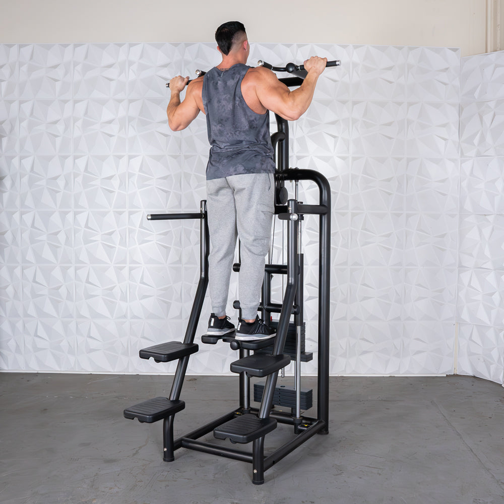 Man using black assisted pull-up machine in gym.