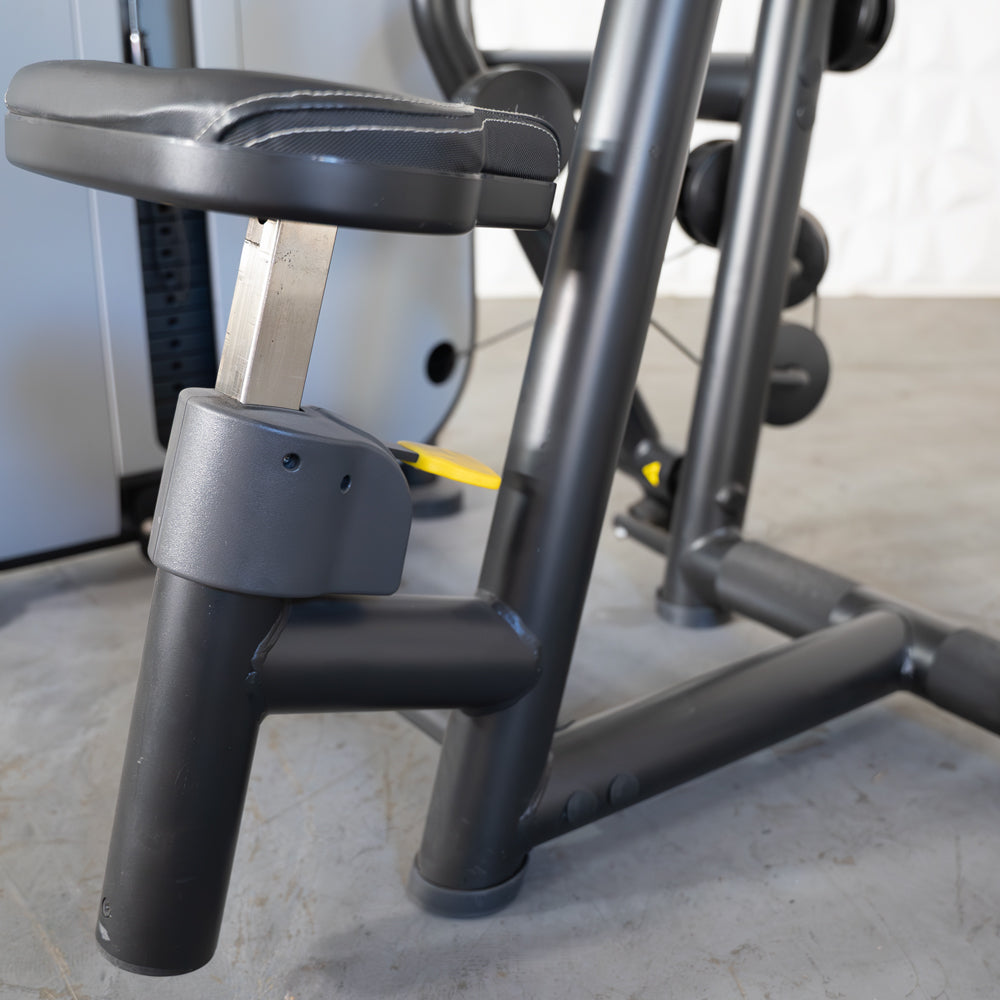 Black adjustable seat of a gym machine with metal support, featuring padded cushion for comfort.