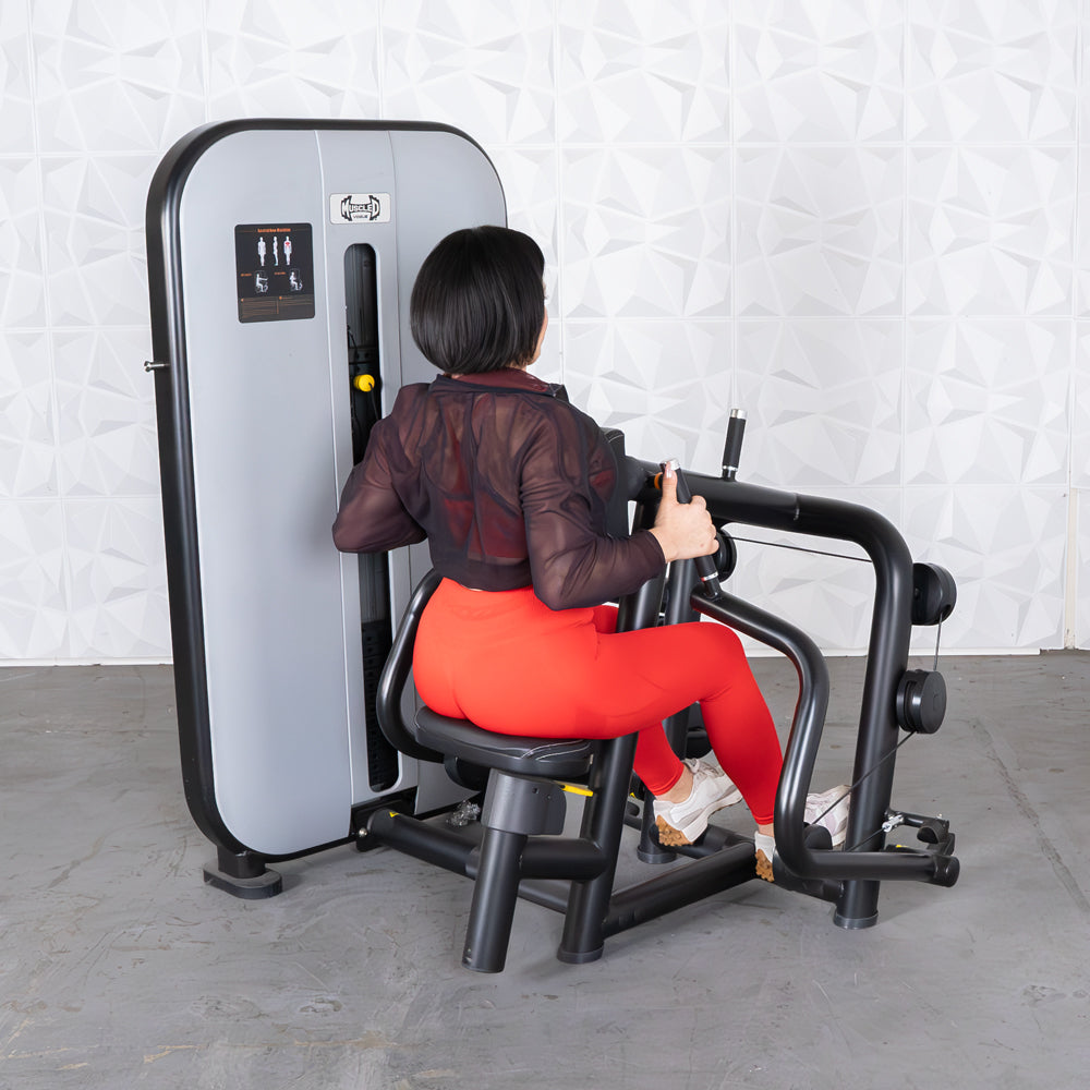 Woman in red leggings using a seated row machine in a gym.