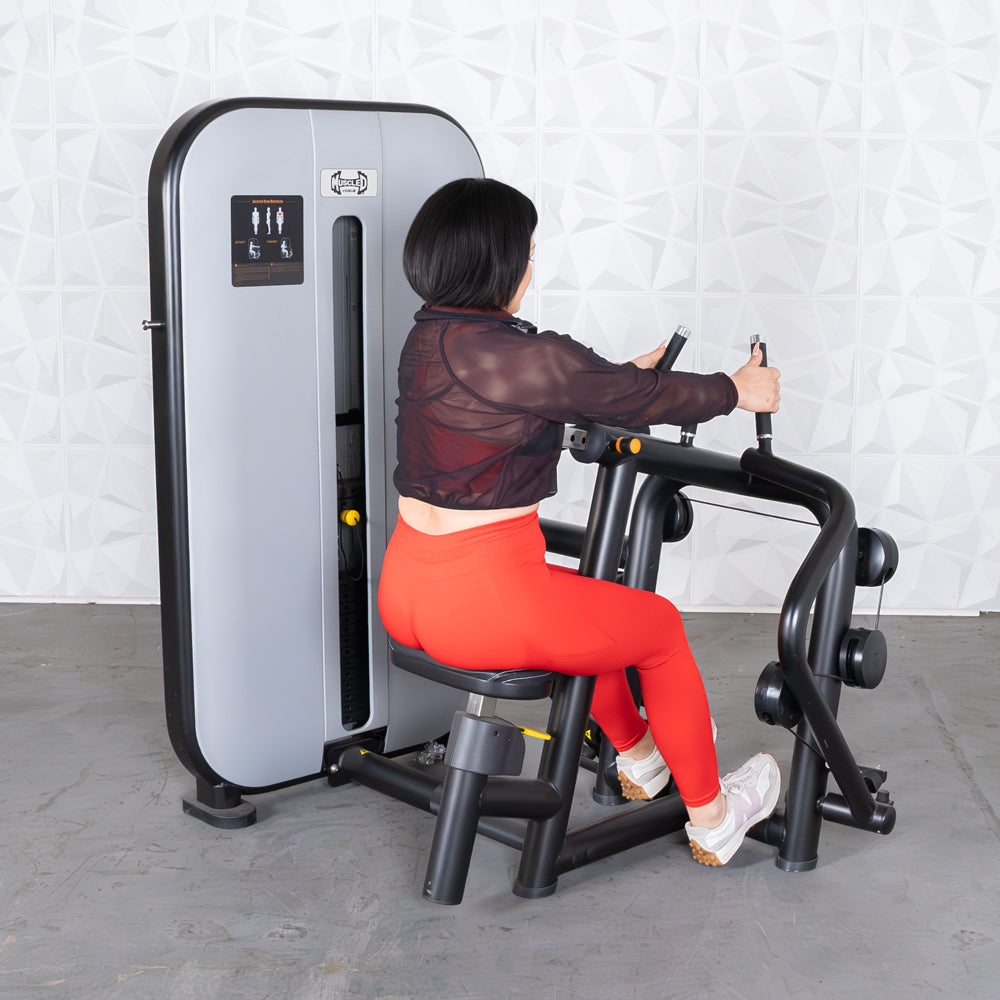 Woman using seated row machine in red leggings at the gym.