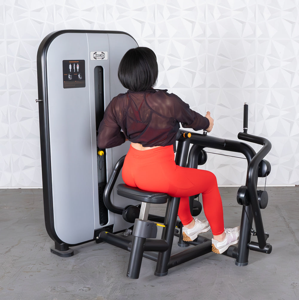 Woman using Muscle D Fitness rowing machine in bright red leggings.