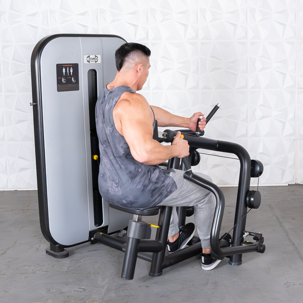 Man using Muscle D Fitness machine for seated row exercise.