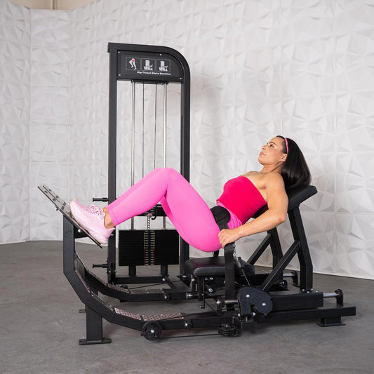 Woman at the top of a hip thrust on the Excel Selectorized Hip Thrust Glute Machine