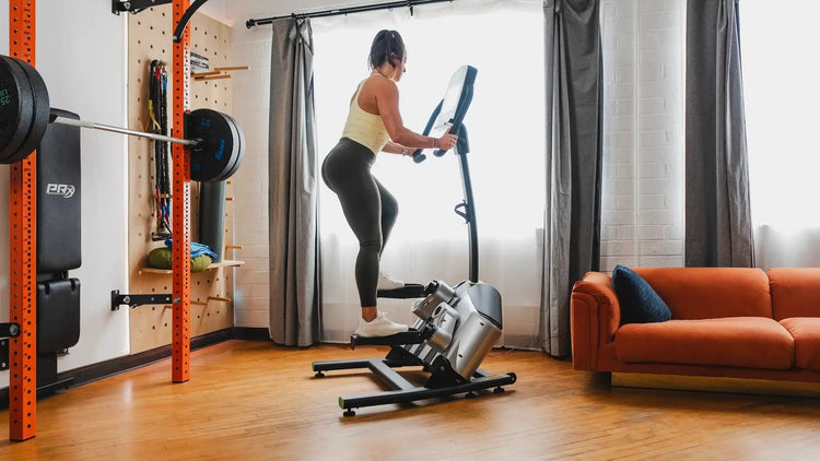 woman using a helix elliptical trainer in a home gym with prx performance