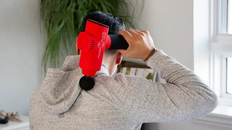 Man using red percussion massager on his back