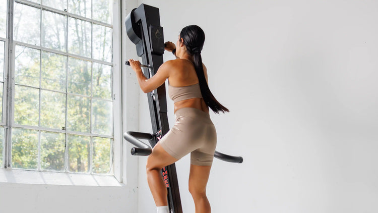 Woman exercising on VersaClimber vertical cardio climber in home living room