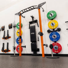 Orange squat rack with weight plates mounted on a gym wall.