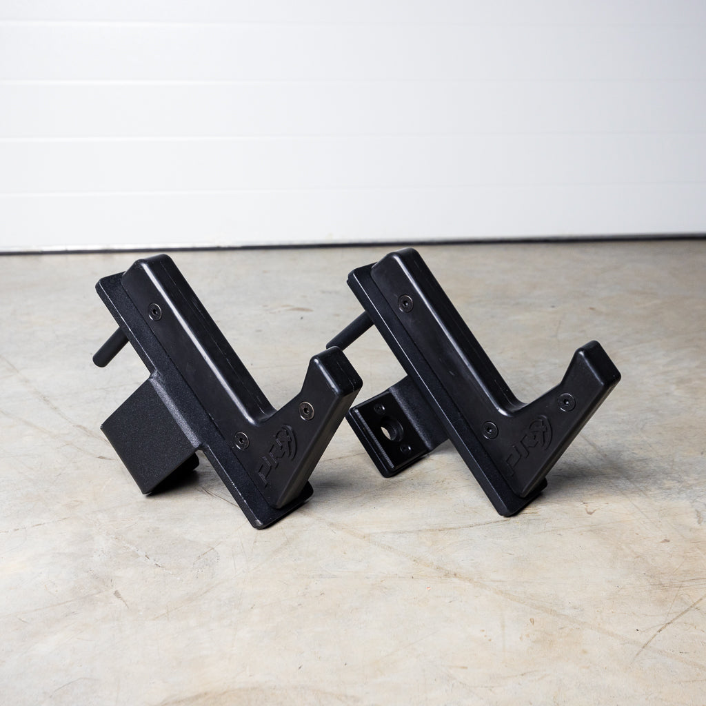Two black metal V-shaped brackets on a concrete floor.