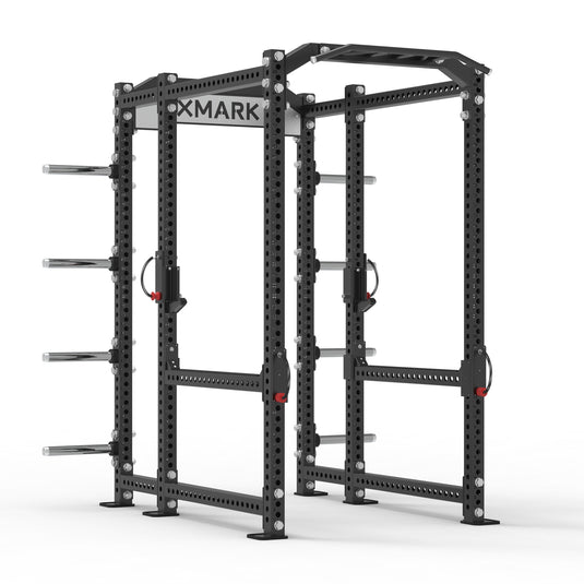 XMARK power rack with barbells and weight plates in a gym setup.