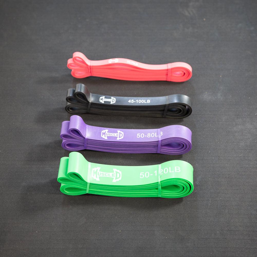 Set of four color-coded resistance bands (red, black, purple, green) with weights.