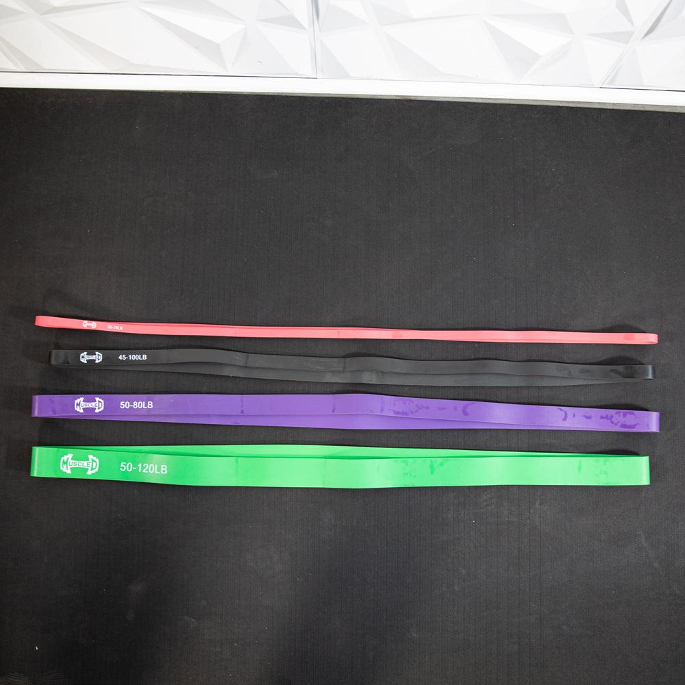Set of four resistance bands in pink, black, purple, and green with LB ranges.