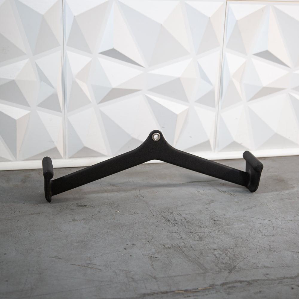 Black metal V-shaped hanger with two ends on a concrete surface.