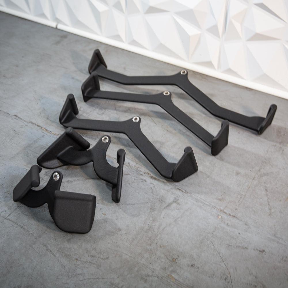 Set of black metal furniture handles and brackets on concrete floor.