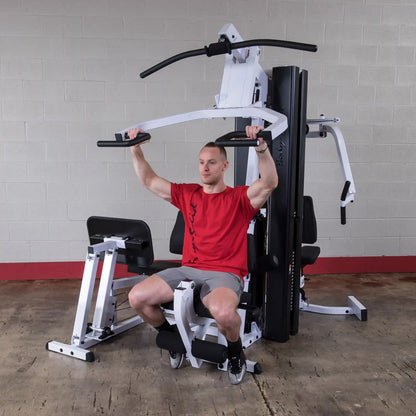 Man using a white multi-gym machine in a red shirt for strength training.