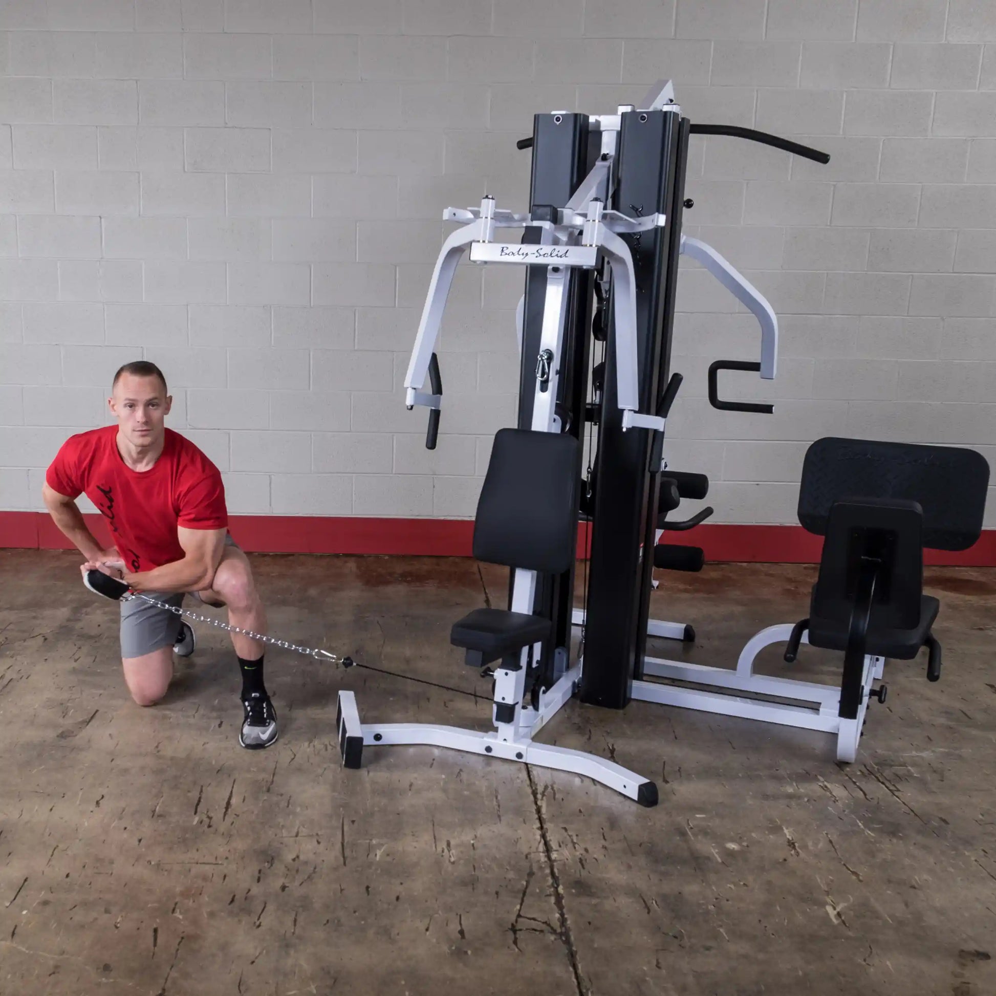 Man using Body-Solid home gym with cable machine for strength training.
