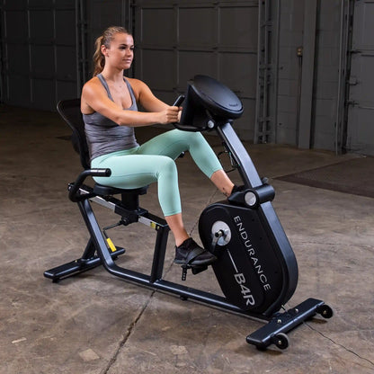 Woman exercising on Endurance B4R recumbent bike in a gym setting.