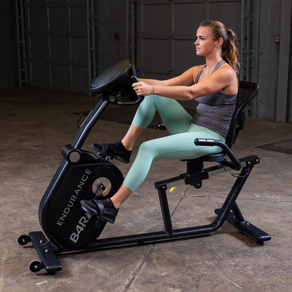 Woman exercising on Endurance B4R recumbent bike in a garage setting.