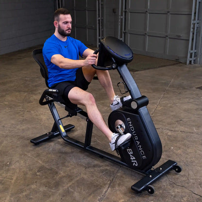 Man exercising on Endurance B4R recumbent bike in a garage.