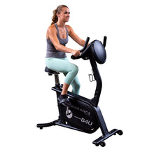 Woman exercising on Durance B4U stationary bike, wearing mint green leggings.
