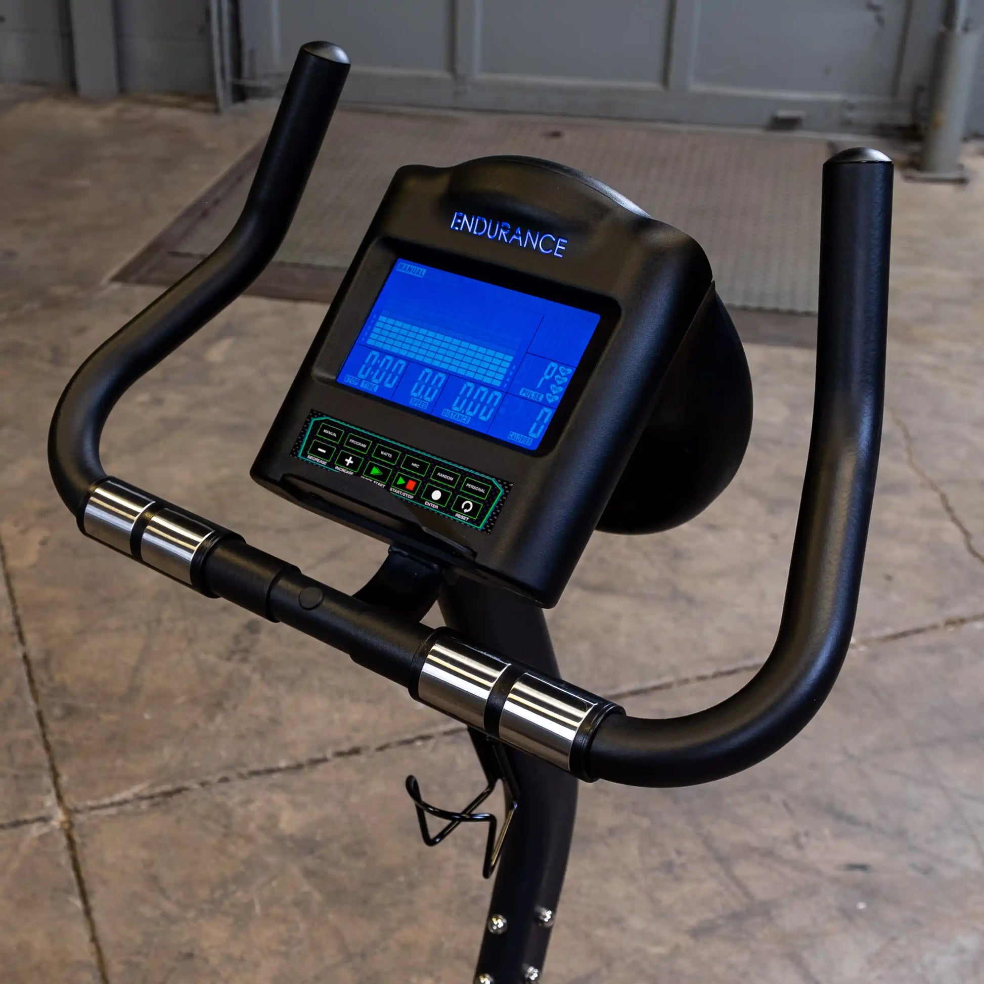 Endurance exercise bike console with digital display and black handlebars.