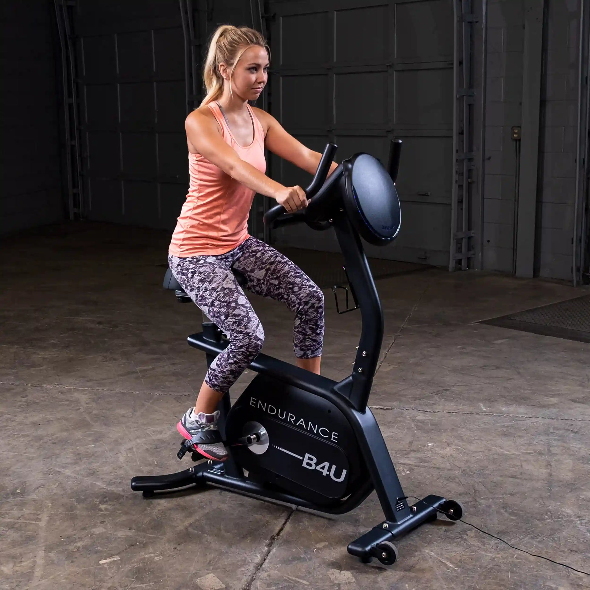 Woman exercising on Endurance B4U stationary bike in a gym.