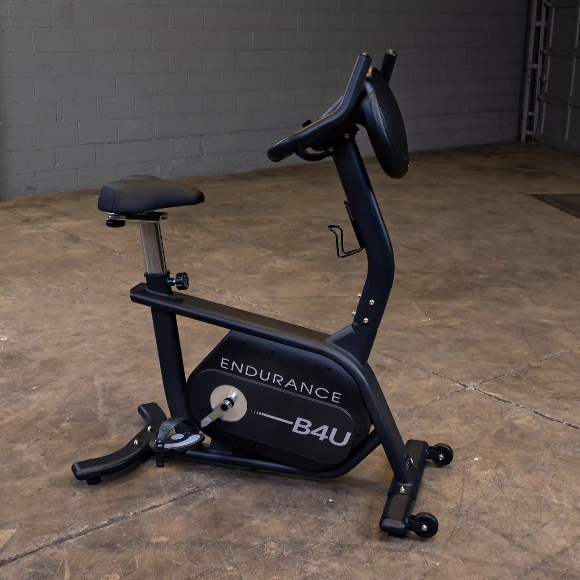 Endurance B4U exercise bike with black frame and adjustable seat in a concrete room.