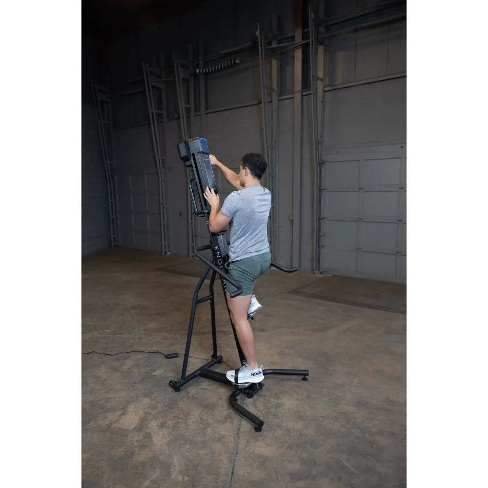Man climbing on a black ENDVR fitness machine indoors.